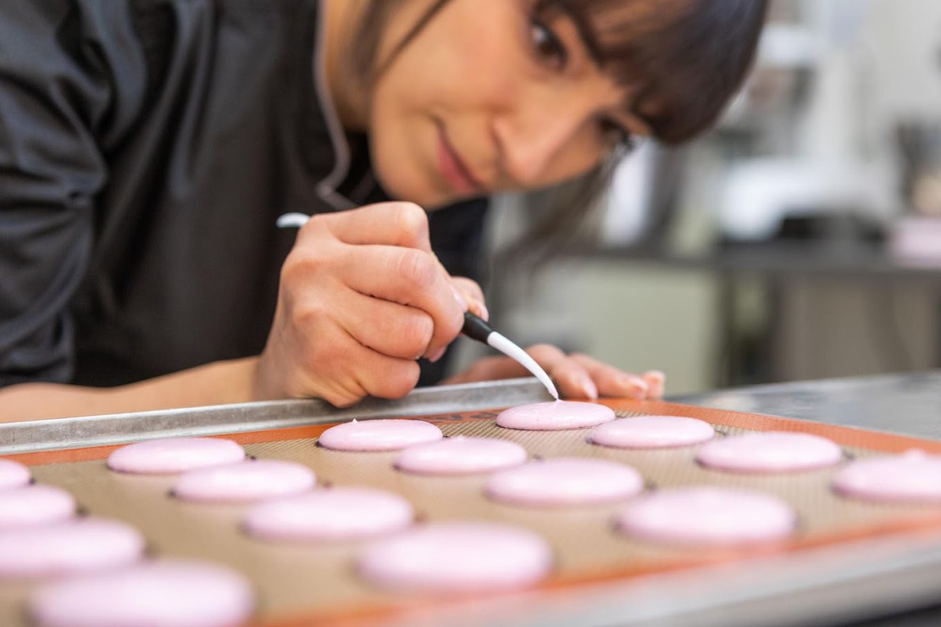 Nihan verziert frische Macarons in der Manufaktur